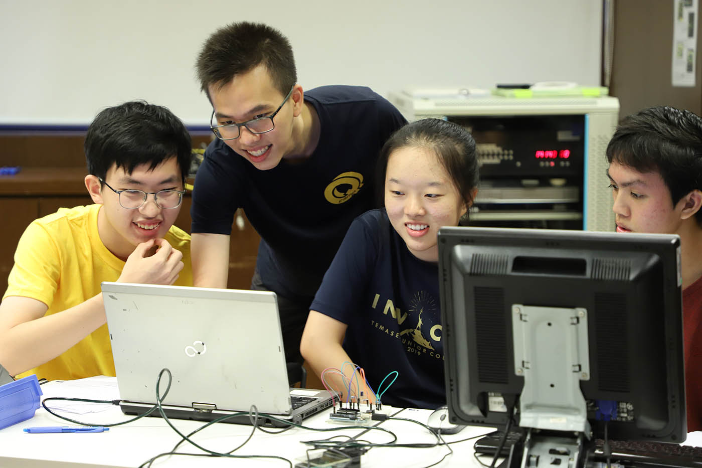 Students pictured with facilitor at the Q Camp workshop, shown working at laptops to control QKD equipment.