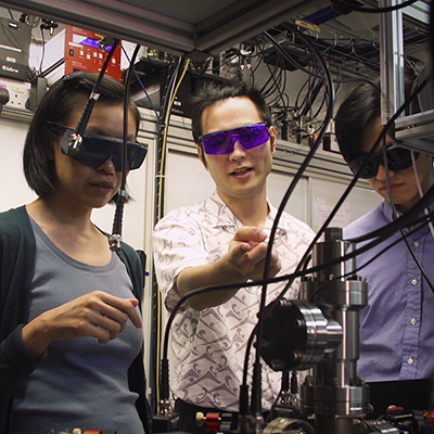 Three scientists in a quantum research lab